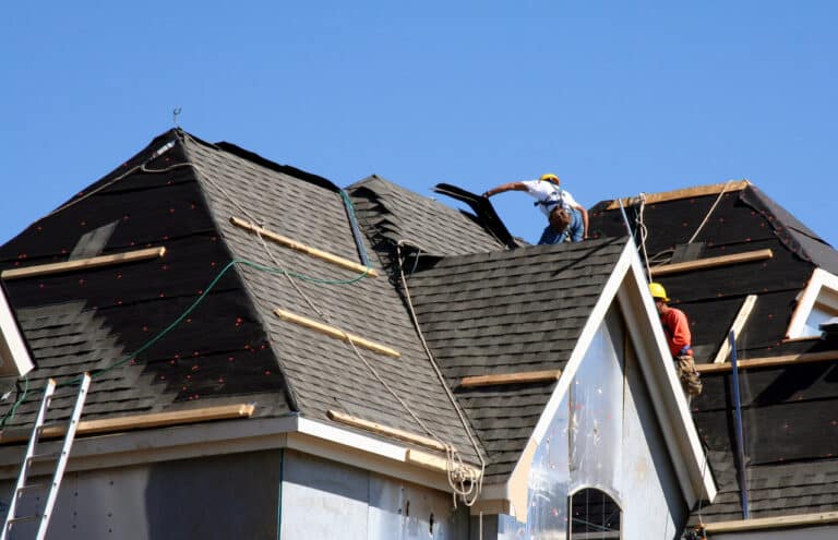 workers putting shingles on the roof